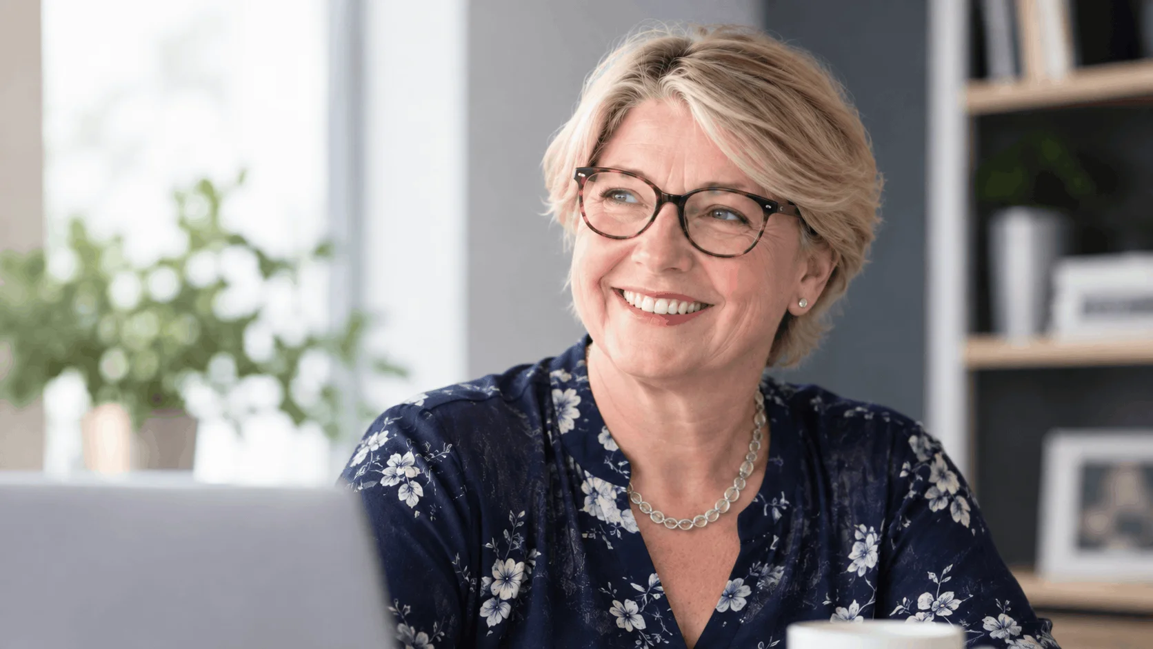 Smiling professional woman with glasses in a modern office setting