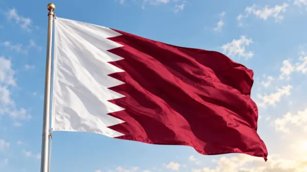 The maroon and white national flag of Qatar waving in the wind